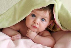Фотографируя совсем маленького малыша, положите его на кровать, накройте одеялом, открыв лишь часть личика